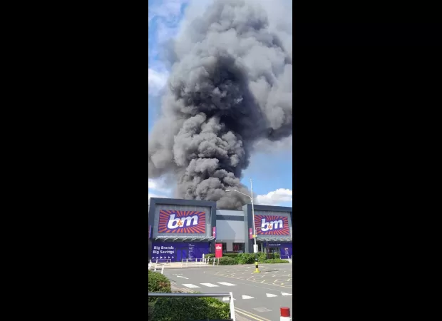 A massive fire at a factory, with smoke seen from 15 miles away.