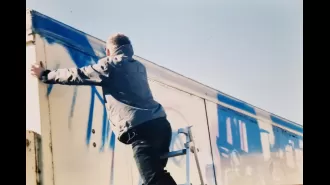 Rare images of Banksy captured during his early days as a street artist, painting a mural before he gained worldwide recognition.