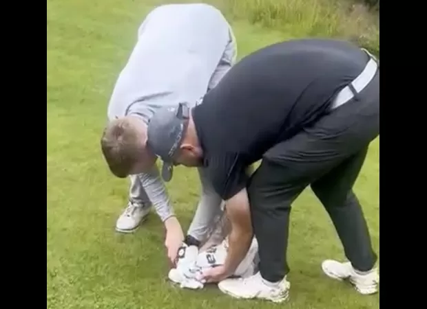 Group of men free seagull caught in net on golf course and give it food from Greggs.