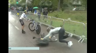 A mechanic in the US falls during the rainy women's time trial at the Paris Olympics.