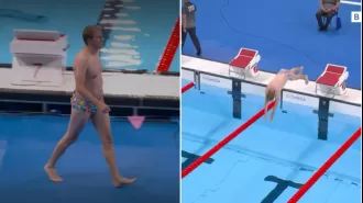 An unknown man wearing flashy swim trunks jumps into the Olympic swimming pool.