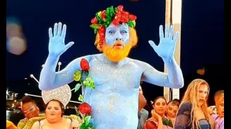 A man painted blue at the Olympics opening ceremony defends himself against criticism and says he endured pain to perform.