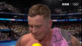 BBC reporter comforts Adam Peaty after he falls short of Olympic gold by 0.02 seconds in Team GB's race.