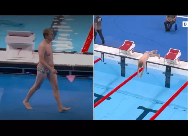 An unknown man wearing flashy swim trunks jumps into the Olympic swimming pool.