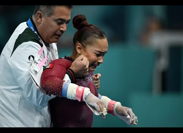 Injured gymnast perseveres through Olympic routine despite torn ligament, finishing in tears.