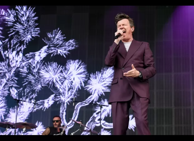 An 80s legend sings a disliked song while riding on a trailer at unexpected appearance at Latitude Festival.