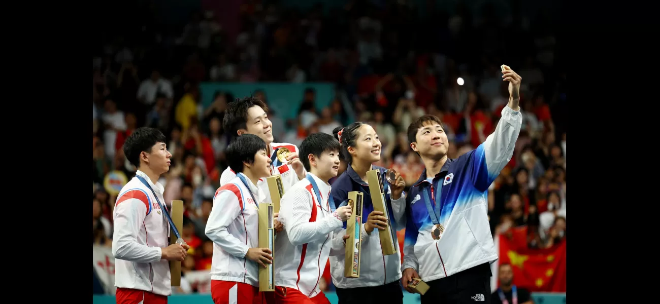 North and South Korean athletes take iconic Olympics selfie.