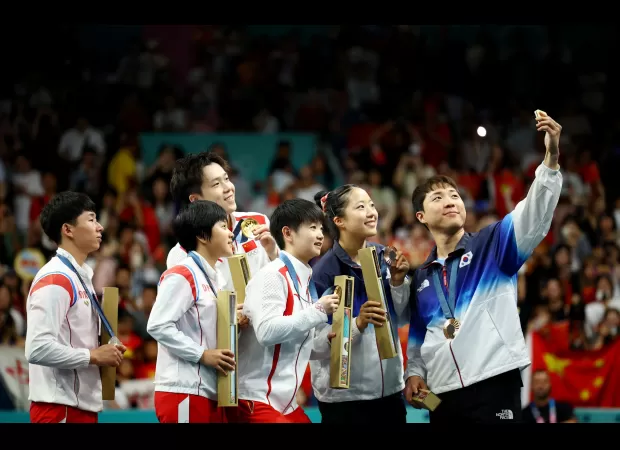 North and South Korean athletes take iconic Olympics selfie.