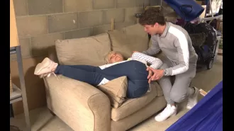 Famous EastEnders star holds her back in pain after being hit by falling sofa.