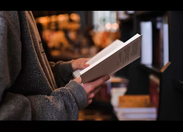 A thief pauses from stealing to read a book.