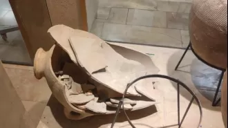 A child unintentionally breaks an ancient pitcher at a museum.