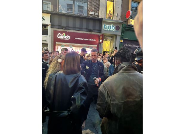 Coldplay surprises fans with unconventional 'barefoot' street performance of their hit song, repeated 5 times.