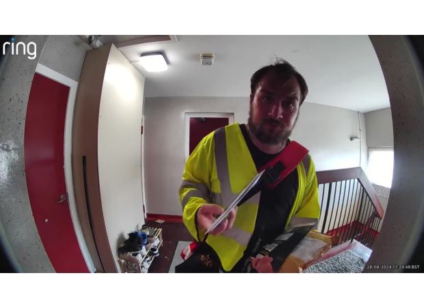 Postal worker stops to smell white sneaker, causing concern.