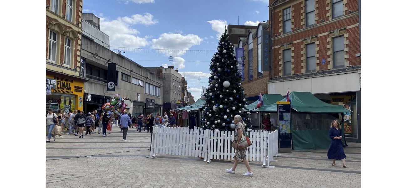 Town center displays Christmas tree unusually early, over 100 days before Christmas.