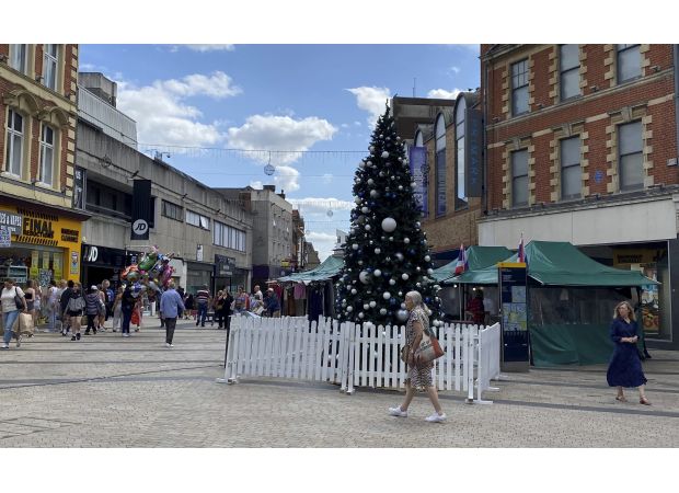 Town center displays Christmas tree unusually early, over 100 days before Christmas.