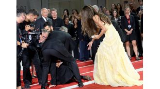 Hollywood star George Clooney saves the day following mishap at Venice film festival premiere.