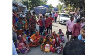 Women protest road closure because of slow Aadhaar linking process.