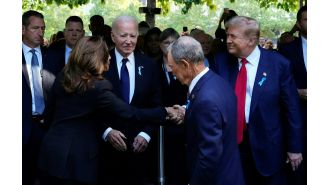 Trump greets Harris with insincere smile, leaning over Biden.