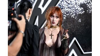 Singer Chappell Roan curses at photographers at VMAs while wearing provocative outfit with sword.