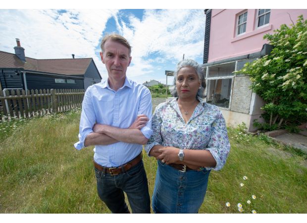 A couple who were forbidden from viewing their neighbor's house are no longer facing charges.