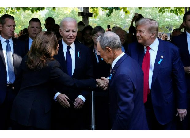 Trump greets Harris with insincere smile, leaning over Biden.