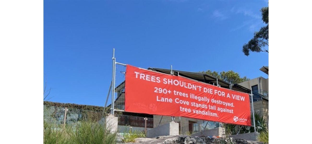 City officials put up a banner to hide the view after many trees were damaged.
