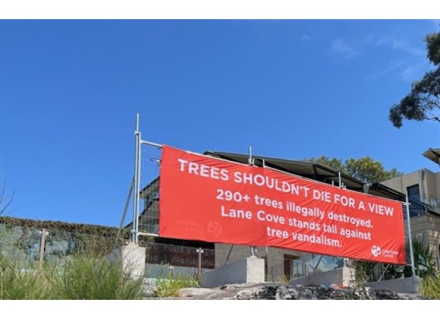 City officials put up a banner to hide the view after many trees were damaged.