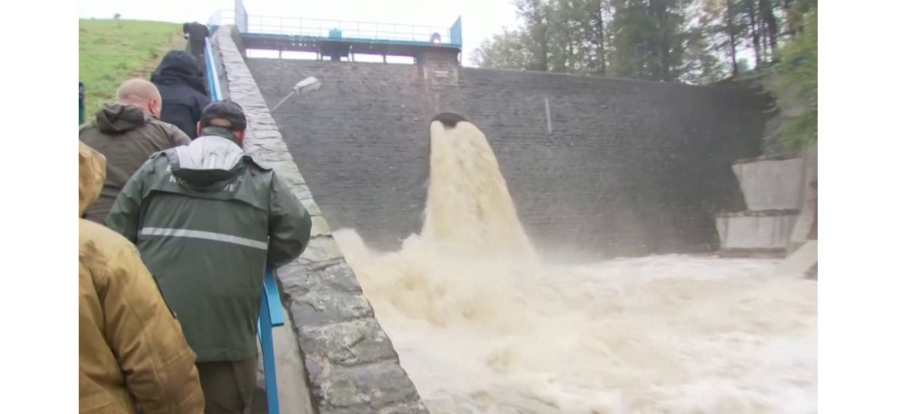 A town is completely flooded after a dam breaks, causing a catastrophic event.