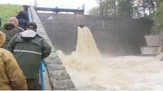 A town is completely flooded after a dam breaks, causing a catastrophic event.