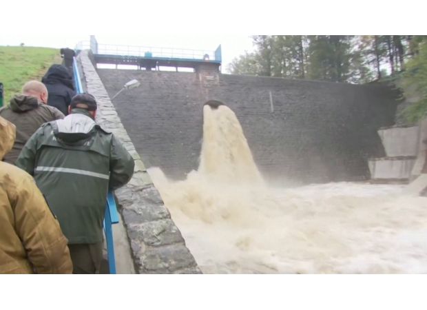 A town is completely flooded after a dam breaks, causing a catastrophic event.