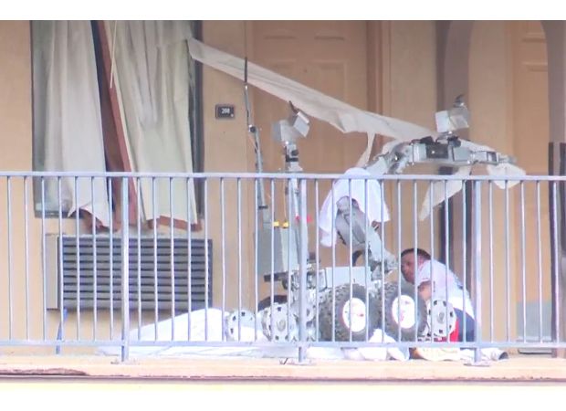 A man battling a police robot is hit with tear gas and run over by it.