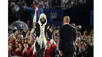 A masked torchbearer at the Olympics was disappointed when people assumed they were a man.