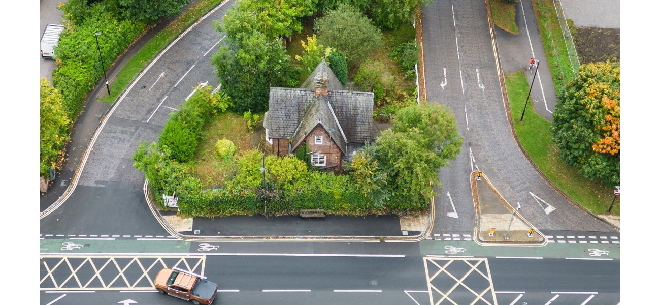 Why is there a solitary house in the middle of a traffic island?