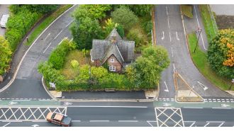 Why is there a solitary house in the middle of a traffic island?