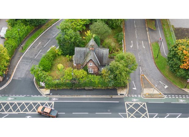 Why is there a solitary house in the middle of a traffic island?