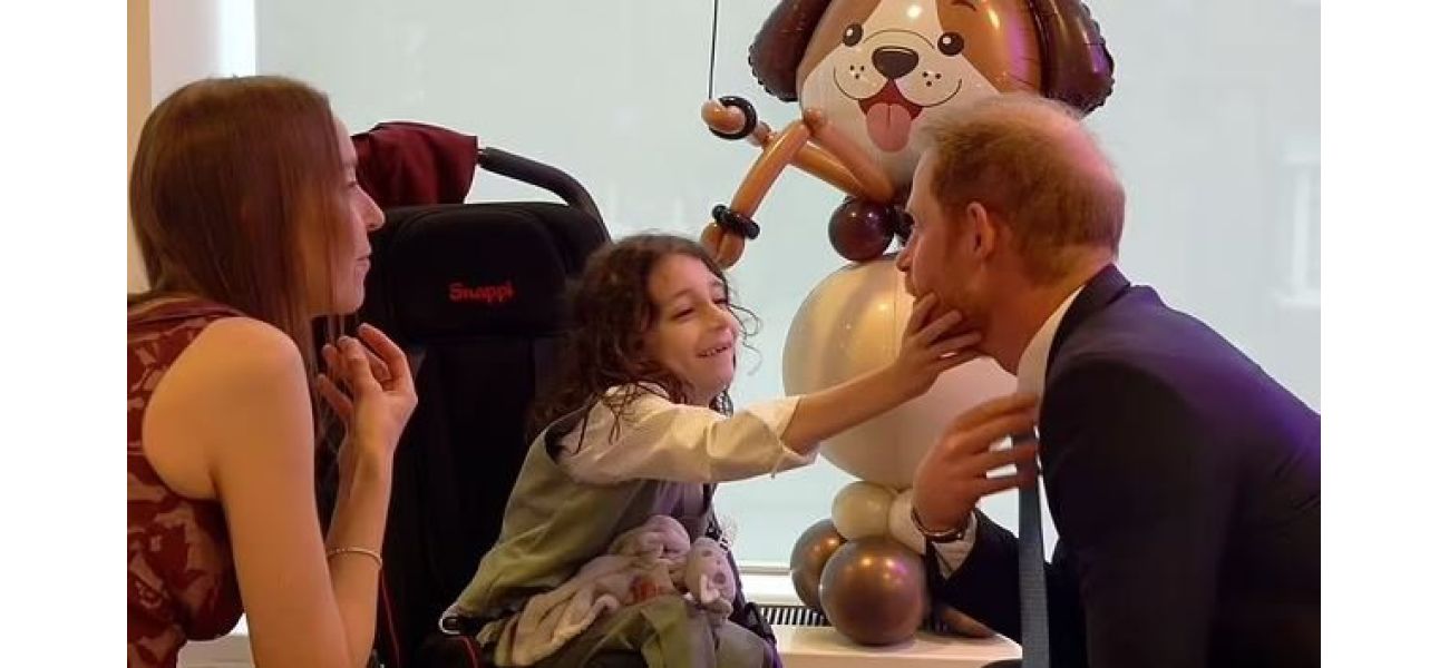 Young boy steals show from Prince Harry at London charity event.