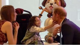 Young boy steals show from Prince Harry at London charity event.