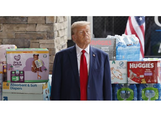 Trump promoting Hurricane Helene aid amidst a backdrop of toilet paper and diapers.