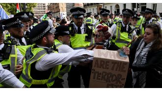 Thousands of protesters in London confront police barrier following large demonstration in city center.