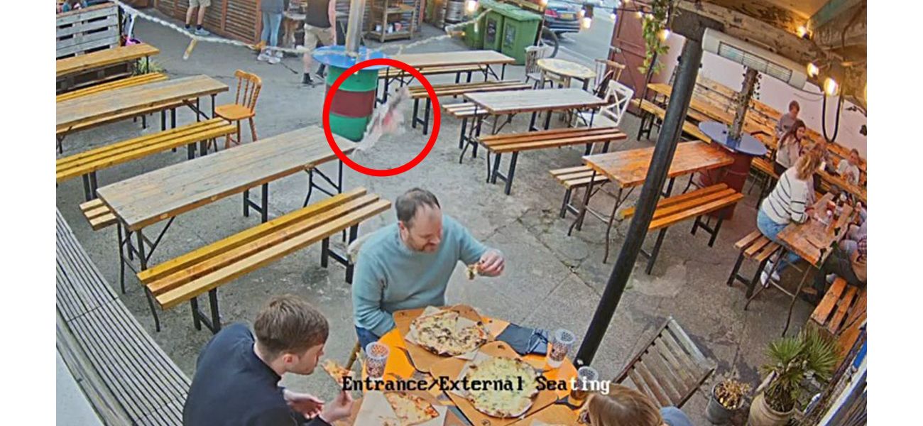 A man eating pizza gets hit by a fish falling from the sky.