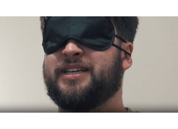 A person cries and shakes while being made to touch a fish.