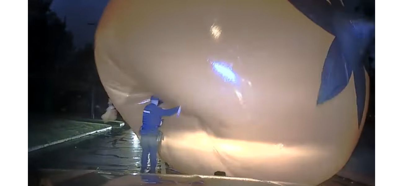 Cop struggles with a huge Halloween pumpkin and gets covered by it.