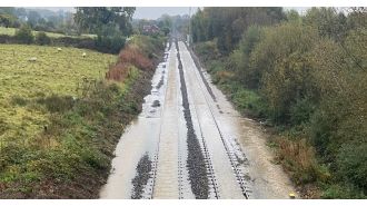 Travel disruptions due to flooding from heavy rain causing chaos on trains and roads in the morning.
