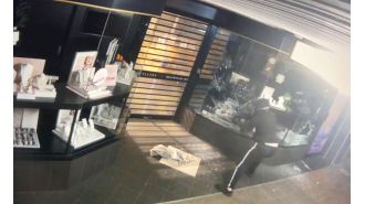 Video footage shows man breaking into old jewelry store with axe.