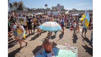 As tourists watch, demonstrators against tourism march through the Canary Islands during the holidays.