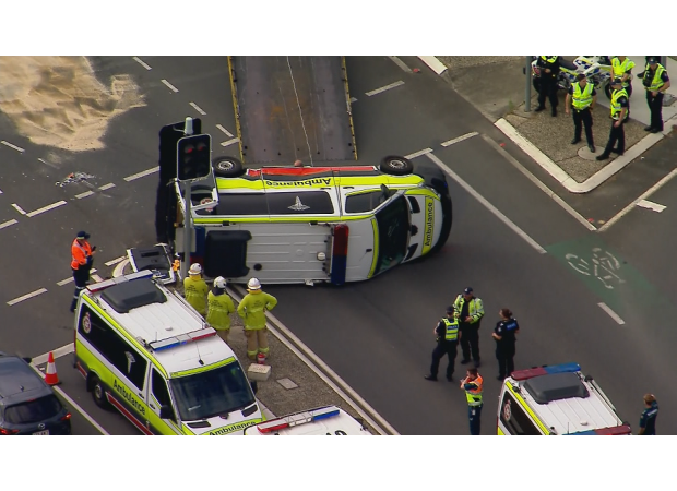 Four people were hurt when an ambulance overturned in Brisbane.