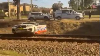 Cops escape train while pursuing biker in Sydney.