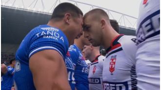 English rugby player clashes with opponent during intense Siva Tau dance in match against Samoa.