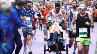 Actor Colin Farrell completes Dublin Marathon while pushing his friend in a wheelchair.