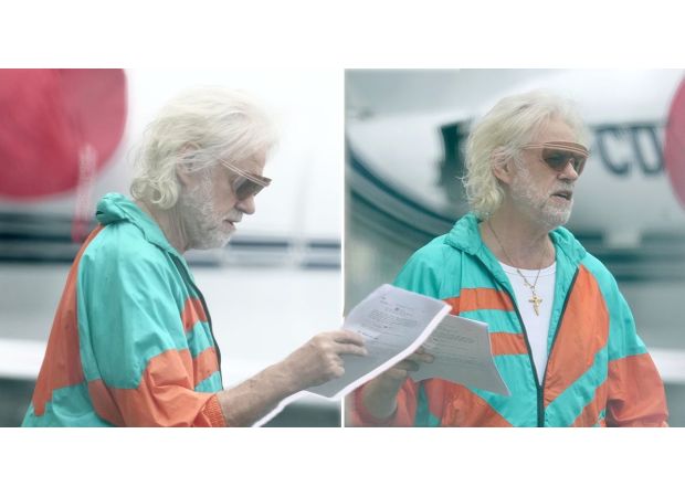 A 1980s rock star looks unrecognizable while making a zombie movie on an airplane.